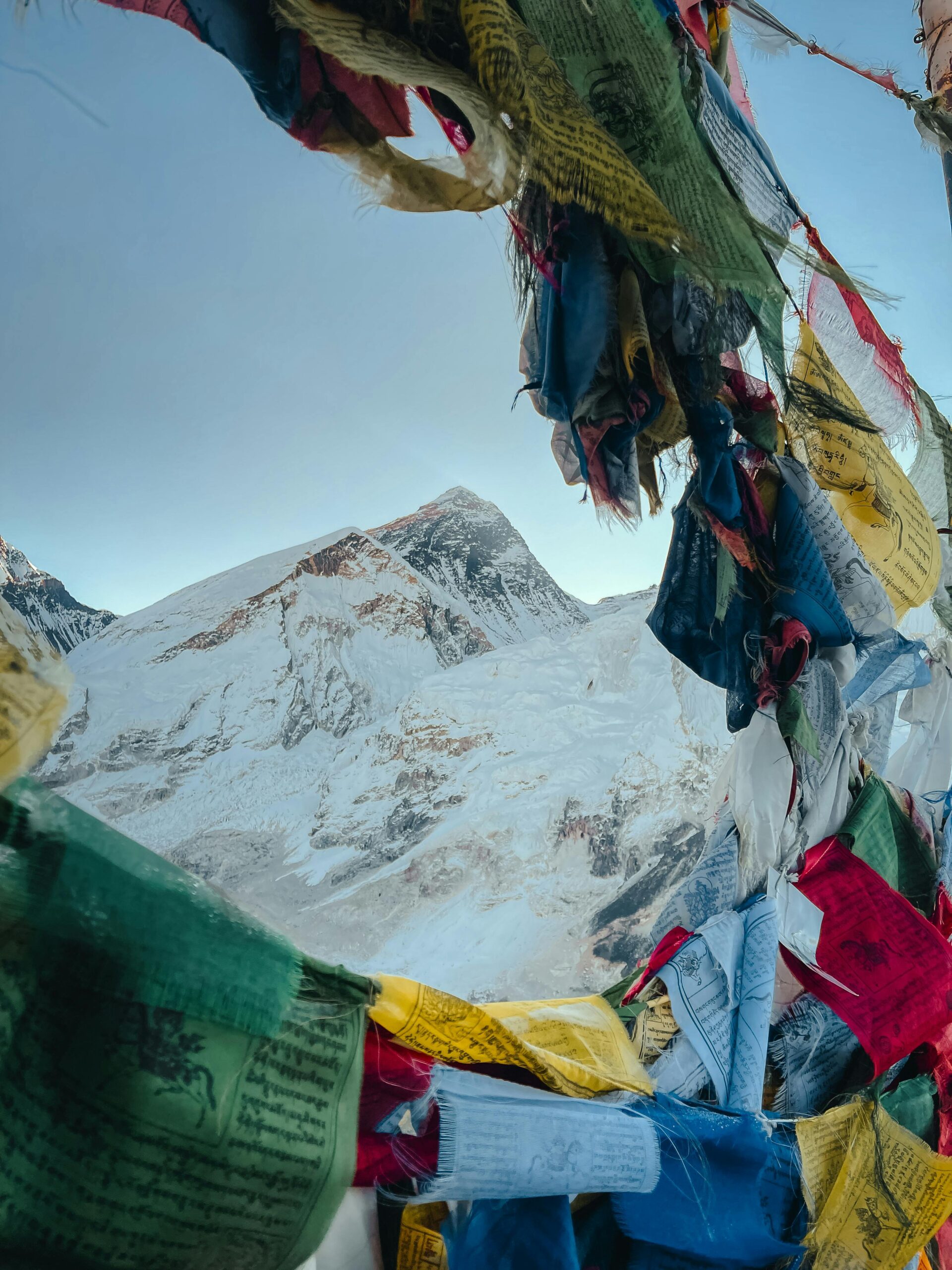 View of Mount Everest framed by colorful Tibetan prayer flags, capturing the peak's grandeur.